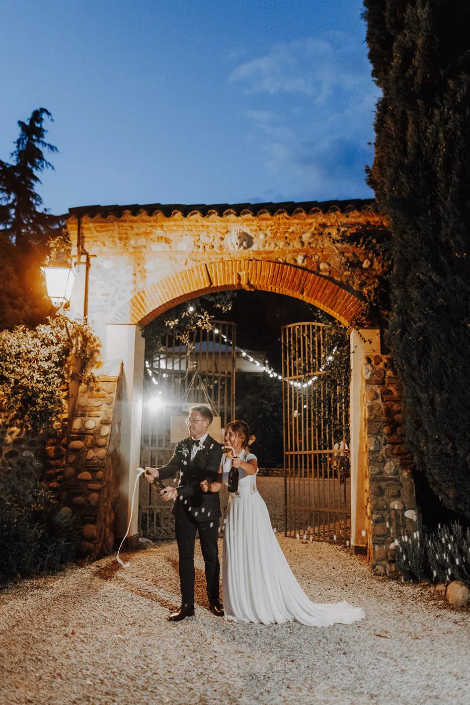 Hochzeit in Italien – Brautpaar bei Nacht vor beleuchtetem Torbogen